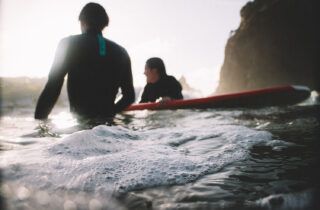 why do surfers wear black wetsuits