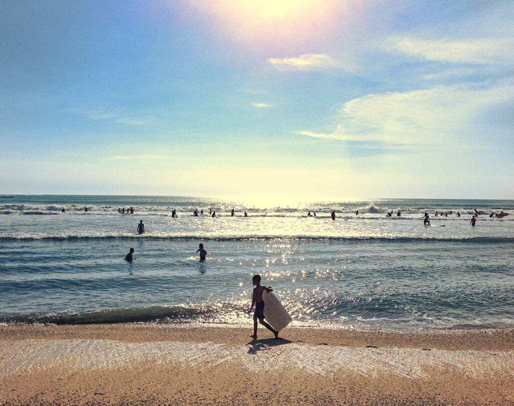 A kid heading out into the water with his bodyboard.